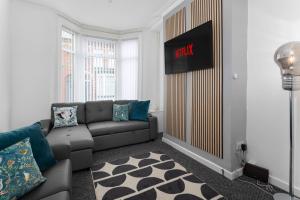 a living room with a couch and a sign on the wall at Woodbine House - Air Host and Stay - Free parking - Contractor Friendly in Liverpool