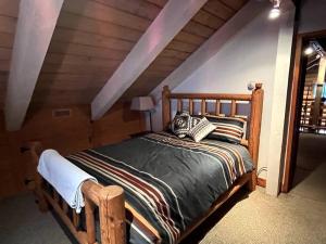 1 dormitorio con cama de madera en el ático en 3-Level Log Cabin near Silverwood - Tranquil, en Spirit Lake
