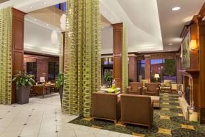 a lobby with yellow columns and chairs and tables at Hilton Garden Inn Bartlesville in Bartlesville