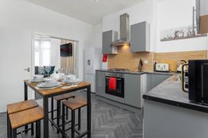a kitchen with a counter and a table with chairs at Woodbine House - Air Host and Stay - Free parking - Contractor Friendly in Liverpool