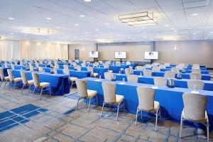 DoubleTree by Hilton Baltimore - BWI Airport في لينثيكوم هايتس: غرفة كبيرة فيها طاولات وكراسي زرقاء