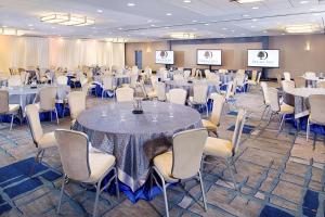 a conference room with tables and chairs and screens at DoubleTree by Hilton Baltimore - BWI Airport in Linthicum Heights