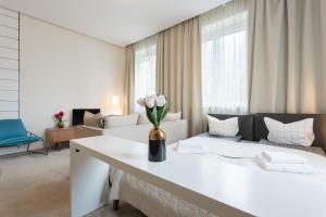 een witte kamer met een bed en een vaas met bloemen bij GA - Bright and Stylish Apartment in the Center - Plac Konstytucji in Warschau