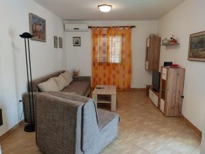 奈維斯的住宿－Apartments Njivice Bajcic，客厅配有沙发和桌子