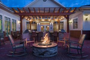 a patio with a fire pit with chairs and a pergola at Homewood Suites by Hilton Buffalo-Amherst in Amherst