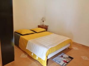 a bedroom with a bed with yellow sheets and a magazine at LE MACADAMIA in Cilaos