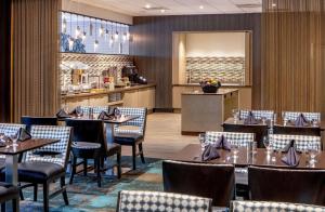 a restaurant with tables and chairs and a counter at DoubleTree by Hilton Columbia in Columbia