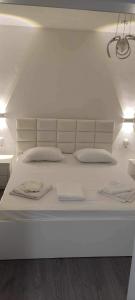 een groot wit bed met 2 kussens erop bij Ilia’s Guesthouse in Pogradec