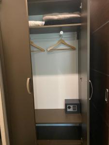 a bathroom with a closet with towels and a scale at Blueline Motel in Jászberény