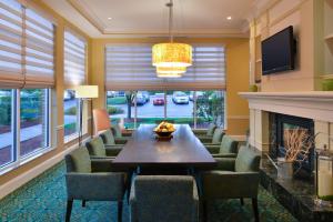 a dining room with a table and chairs and a fireplace at Hilton Garden Inn Columbia in Columbia