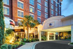 a hotel with a palm tree in front of a building at Hilton Columbia Center in Columbia