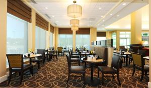 a dining room with tables and chairs and windows at Hilton Garden Inn Columbia/Northeast in Columbia