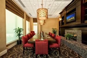 a dining room with a long table and red chairs at Hilton Garden Inn Columbia/Northeast in Columbia