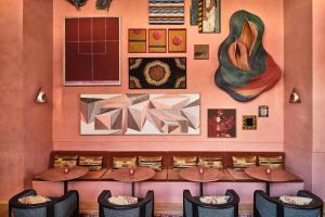 a restaurant with tables and chairs and paintings on the wall at Downtown Los Angeles Proper Hotel, a Member of Design Hotels in Los Angeles