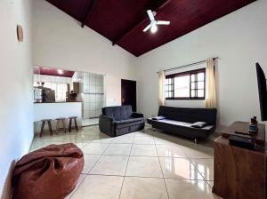 - un salon avec deux canapés et un ventilateur de plafond dans l'établissement Otima casa com WiFi e churrasqueira em Bertioga SP, à Bertioga