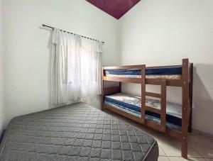 a bedroom with two bunk beds and a window at Otima casa com WiFi e churrasqueira em Bertioga SP in Boracéia +32 photos