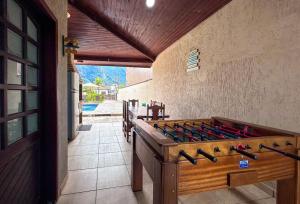 - une salle de jeux avec une grande table de jeux en bois dans l'établissement Otima casa com WiFi e churrasqueira em Bertioga SP, à Bertioga
