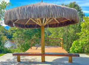 a large straw umbrella sitting on a table at Otima casa com WiFi e churrasqueira em Bertioga SP in Bertioga