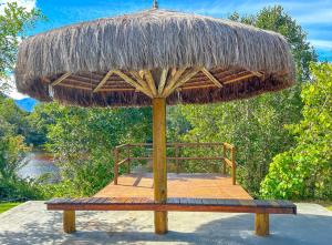 a large straw umbrella sitting on a table at Otima casa com WiFi e churrasqueira em Bertioga SP in Boracéia