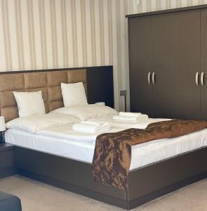 a bedroom with a large bed with white sheets at Blueline Motel in Jászberény +40 photos