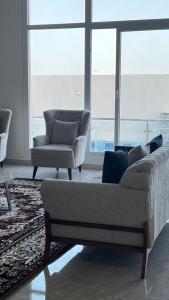 a living room with a couch and two chairs at Al Saad chalet in Al Ashkharah