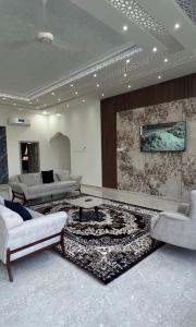 a living room with two couches and a rug at Al Saad chalet in Al Ashkharah