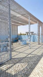 een metalen paviljoen met een tafel en stoelen op een patio bij Al Saad chalet in Al Sharqiyah