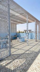 a metal pavilion with a table and chairs on a patio at Al Saad chalet in Al Sharqiyah