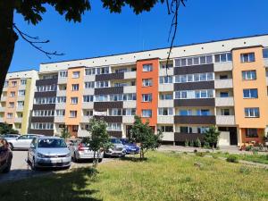 an apartment building with cars parked in a parking lot at Dzintari in Liepāja