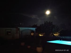 a night view of a pool with the moon in the sky at Vila Rogač in Tivat