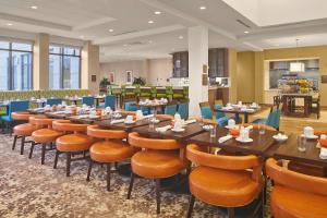 a restaurant with a long table and chairs at Hilton Garden Inn Akron in Akron