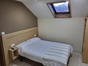 a small bedroom with a bed and a window at CASA MARUXA pensión in Pontevedra