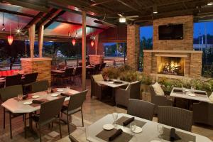 a restaurant with tables and chairs and a fireplace at Hilton Akron Fairlawn in Fairlawn