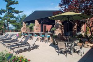 a group of chairs and an umbrella on a patio at Hilton Akron Fairlawn in Fairlawn