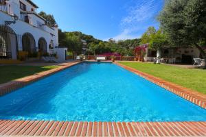 a swimming pool with blue water in a yard at VILLA CLAVERO FOUR Premium Apt in Málaga
