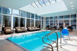 a swimming pool in a hotel lobby with chairs and tables at Hilton Garden Inn Chicago Downtown/Magnificent Mile in Chicago