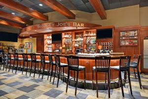 a bar with wooden bar stools in a restaurant at Hilton Garden Inn Chicago Downtown/Magnificent Mile in Chicago