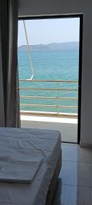 een slaapkamer met uitzicht op de oceaan door een raam bij Christinas 1 in Nerántza