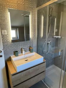 La salle de bains est pourvue d'un lavabo et d'une douche. dans l'établissement Joyful apartments with beautiful view, à Privlaka