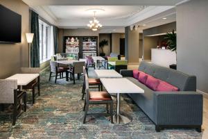 a restaurant with tables and chairs and a couch at Hampton Inn Freeport in Freeport