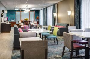 um restaurante com mesas e cadeiras e uma sala de espera em Hampton Inn Freeport em Freeport