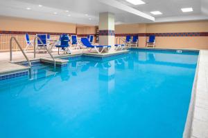 una gran piscina con sillas azules en una habitación de hotel en Hampton Inn Freeport en Freeport