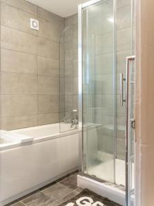 a bathroom with a shower and a tub and a sink at Amazing Entire 4 Bedroom Home in Manchester