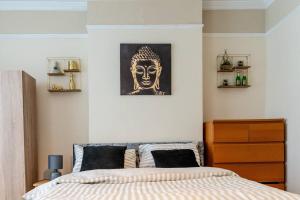 a bedroom with a bed with a painting of a head at Amazing Entire 4 Bedroom Home in Manchester