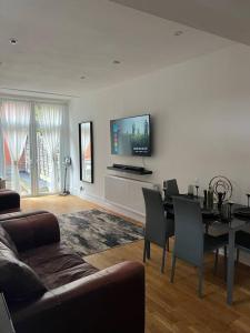 a living room with a couch and a table with chairs at Amazing Entire 4 Bedroom Home in Manchester