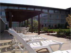 a row of white lounge chairs in front of a building at DoubleTree by Hilton Libertyville-Mundelein in Mundelein