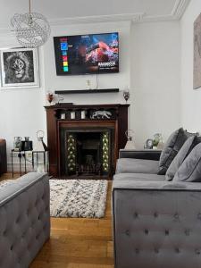 uma sala de estar com lareira e uma televisão na parede em Amazing Entire 4 Bedroom Home em Manchester