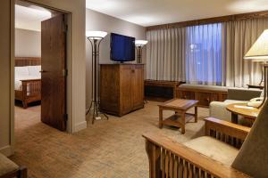 a hotel room with a living room with a television at DoubleTree by Hilton Libertyville-Mundelein in Mundelein