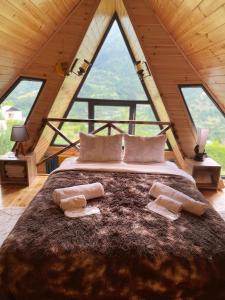 ein großes Bett in einem Zimmer mit großen Fenstern in der Unterkunft Forest House in Dandalo