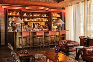 un bar en una habitación con sillas y mesa en Austin Proper Hotel, a Member of Design Hotels en Austin